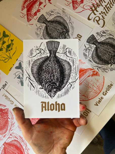 Postkarte mit einer Flunder und Frakturschrift Aloha