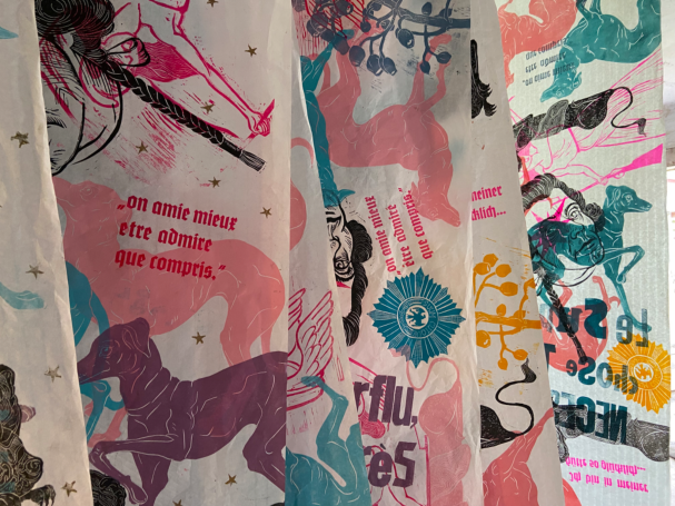 Bunte Stoffe mit Mustern von Pferden und typografischen Elementen.