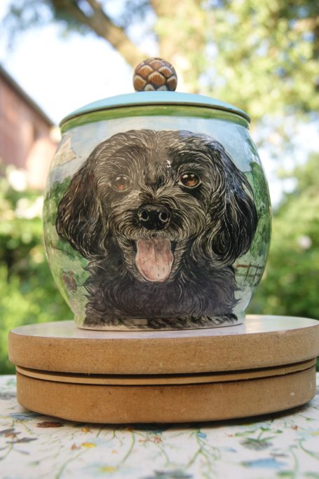 kleine Urne mit schwarzem Hund