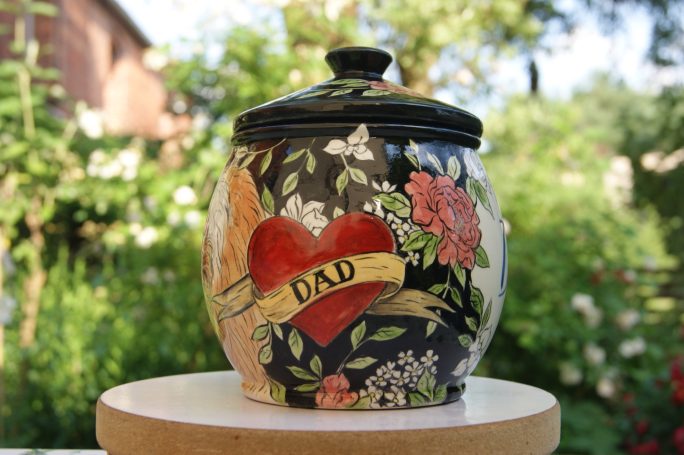 Seitenansicht einer Urne mit einem Herz und Blumen