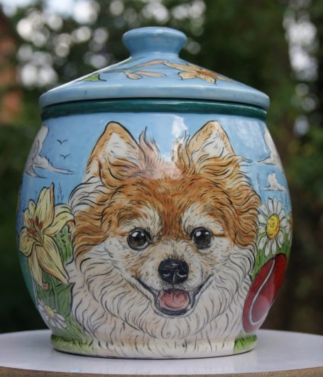 handbemalte Urne für einen Pomeranien mit Blumen im Hintergrund